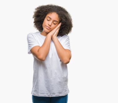 Uyku yorgun hayal ve ellerle birlikte poz ile kapalı gözler gülümseyen izole arka plan üzerinde genç afro Amerikalı kadın.