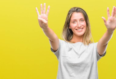 Genç güzel kadın gösterilen ve parmakları ile işaret izole arka plan üzerinde numara 9 kendinden emin ve mutlu gülümseyerek süre.