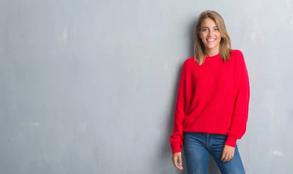 Piękna Młoda Kobieta Stojący Streszczenie Szary Mur Swetrze Zima Szczęśliwy — Zdjęcie stockowe