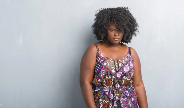 身に着けているカラフルなドレスの懐疑論者と神経 しかめっ面の動揺問題のため灰色のグランジの壁を越えて若いアフリカ系アメリカ人女性 否定的な人 — ストック写真