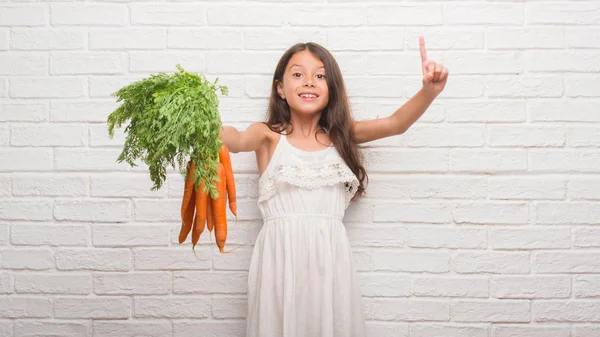 Молодой Латиноамериканец Стене Белого Кирпича Держа Руках Свежую Морковку Удивленный — стоковое фото