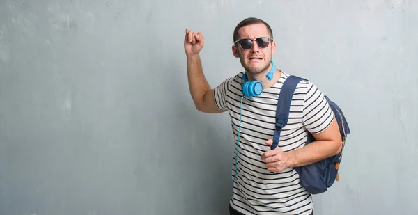 Junger Kaukasischer Student Über Graue Grunge Wand Mit Kopfhörern Und — Stockfoto