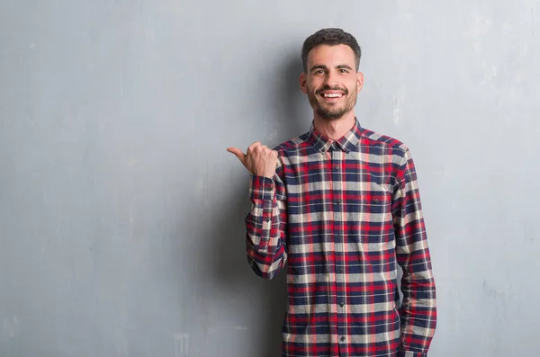 Young Adult Man Standing Grey Grunge Wall Pointing Showing Thumb — Stock Photo, Image