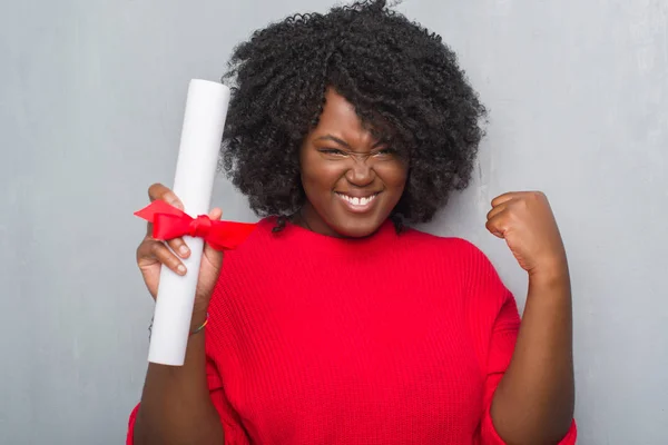 Unga Afroamerikanska Kvinnan Över Grå Grunge Väggen Håller Diplom Skrek — Stockfoto