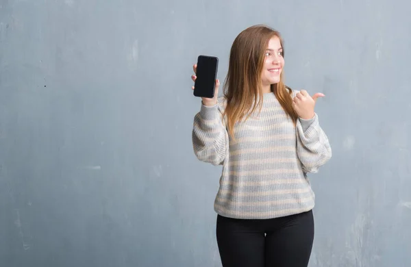 Jonge Volwassen Vrouw Grijs Grunge Muur Weergegeven Leeg Scherm Van — Stockfoto