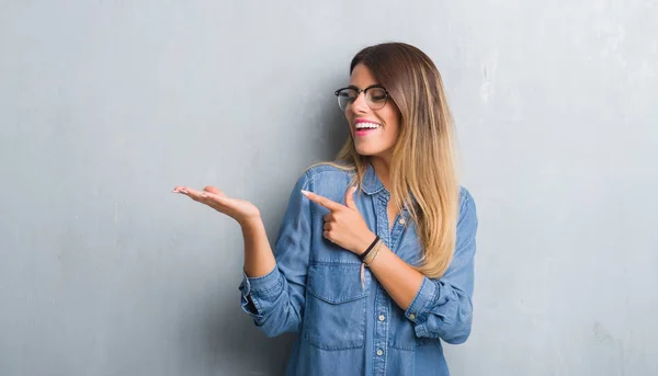 Joven Mujer Adulta Sobre Pared Gris Grunge Usando Gafas Sorprendidas —  Fotos de Stock