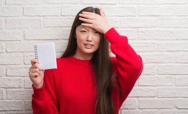 Young Chinese Woman Brick Wall Showing Blank Notebook Stressed Hand — Stock Photo, Image