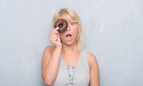 Donna Adulta Caucasica Sopra Parete Grigia Grunge Mangiare Ciambella Cioccolato — Foto Stock