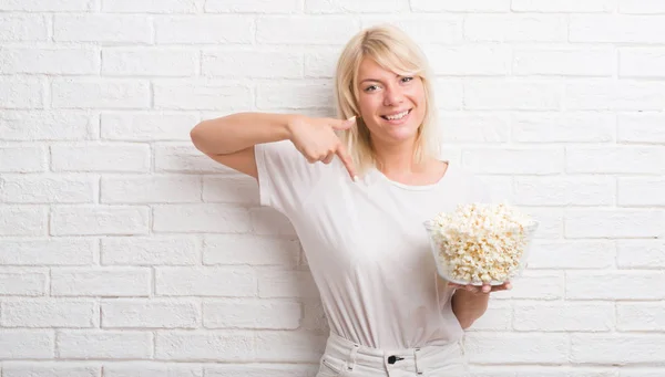 Mujer Caucásica Adulta Sobre Pared Ladrillo Blanco Comiendo Maíz Pop —  Fotos de Stock