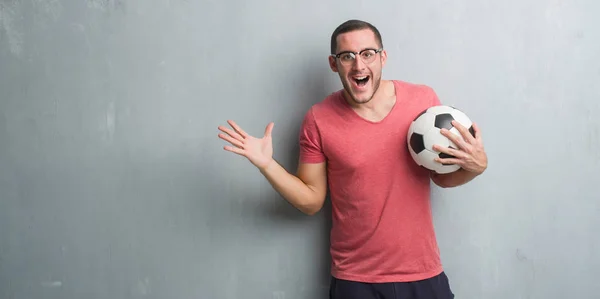 Junger Kaukasischer Mann Über Grauer Grunge Wand Mit Fußballball Sehr — Stockfoto