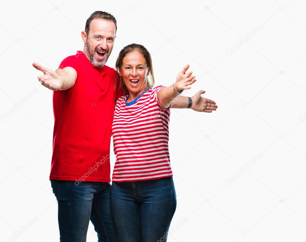 Middle age hispanic couple in love over isolated background looking at the camera smiling with open arms for hug. Cheerful expression embracing happiness.