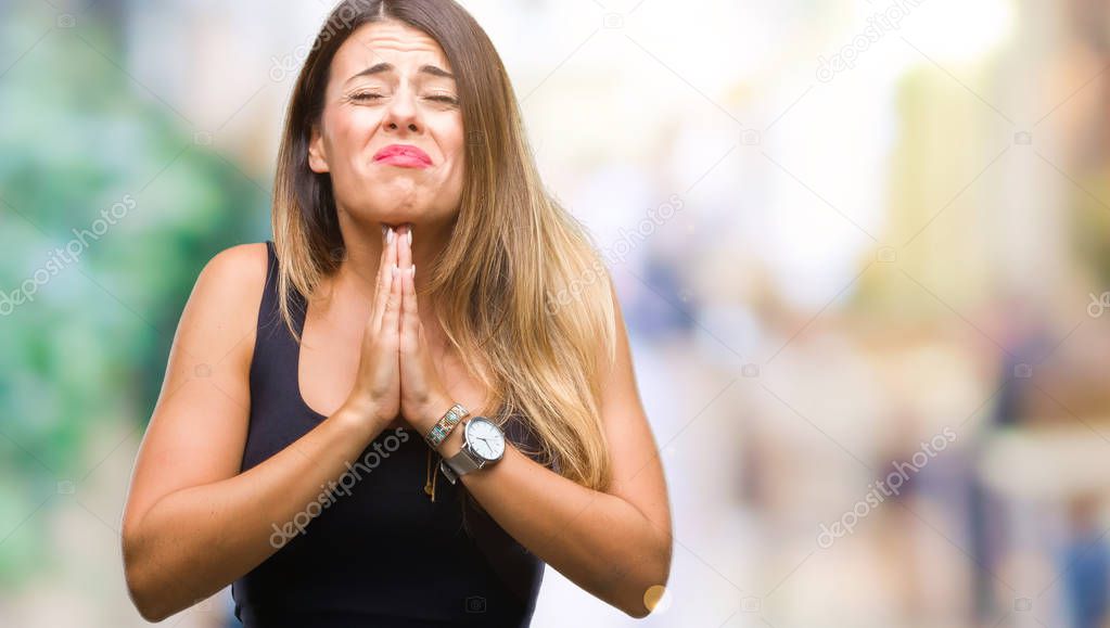 Young beautiful woman over isolated background begging and praying with hands together with hope expression on face very emotional and worried. Asking for forgiveness. Religion concept.