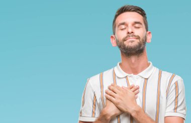 Yakışıklı delikanlı ile gülümseyen izole arka plan üzerinde kapalı gözler ve yüzünde minnettar jest ile göğüs üzerinde eller. Sağlık kavramı.