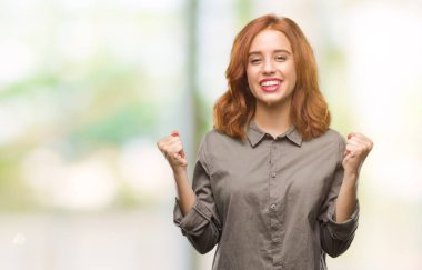 İzole arka plan kutlama üzerinde genç güzel kadın şaşırttı ve başarı için kaldırdı kollarını açarak hayret ve gözleri açık. Kazanan kavramı.