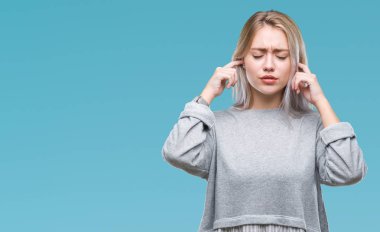 Genç Sarışın kadın parmakları ile yüksek sesle müzik gürültü rahatsız ifade kulaklarıyla kapsayan izole arka plan yüzünden. Sağır kavramı.