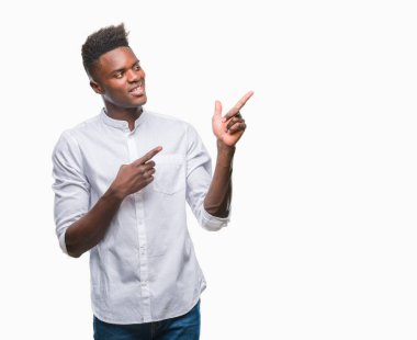 Gülümseyen ve iki elleri ve parmakları ile tarafına işaret kamera bakarak izole arka plan üzerinde genç Afro-Amerikan adam.