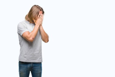 Yüzünü elleriyle ağlayarak süre kapsayan üzgün ifade ile izole arka plan üzerinde uzun saçlı Genç yakışıklı adam. Depresyon kavramı.
