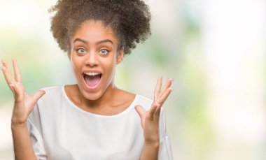 Genç afro Amerikan kadın deli kutluyor ve silah ile başarı için heyecanlı çığlık kaldırdı ve açık gözleri hayret izole arka plan yüzünden. Kazanan kavramı