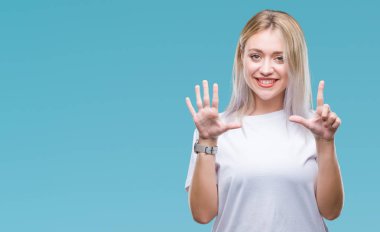 Genç Sarışın kadın gösterilen ve parmakları ile işaret izole arka plan yüzünden kendinden emin ve mutlu gülümseyerek süre yedi numara.
