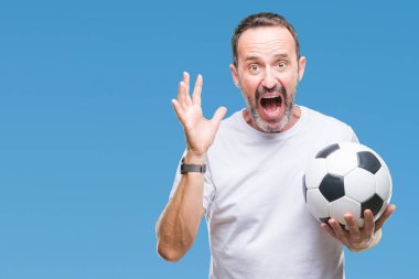 Orta yaş ağarmış komuta sizde futbol futbol topu tutan kocaman bir gülümseme ile çığlık zaferini kutluyor arka plan çok mutlu ve heyecanlı, kazanan ifade izole ve ellerini kaldırdı