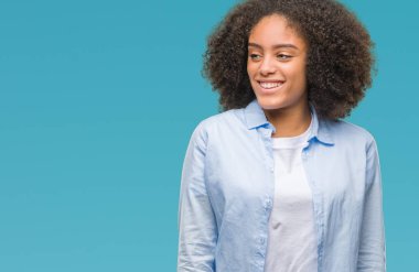 Uzak tarafına yüzünde, doğal ifade gülümseme ile seyir izole arka plan üzerinde genç afro Amerikalı kadın. Kendine güvenen gülüyor.