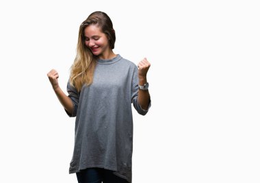 Gülümseyen ve başarı için çığlık genç güzel sarışın kadın izole arka plan çok mutlu ve heyecanlı kaldırdı, silah ile kazanan jest yapıyor. Kutlama kavramı.