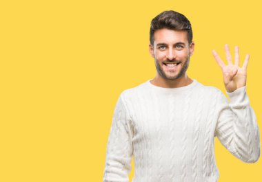 Gösterilen arka plan üzerinde kış kazak giyen genç yakışıklı adam izole ve parmakları ile işaret kendinden emin ve mutlu gülümseyerek süre dört numara.