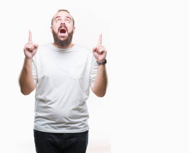 İzole arka plan üzerinde rahat t-shirt giyen genç beyaz hipster adam hayret ve yukarıya bakıp parmakları ile işaret şaşırttı ve silah kaldırdı.