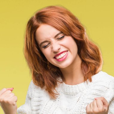 Gülümseyen ve başarı için çığlık genç güzel kadın izole arka plan çok mutlu ve heyecanlı kaldırdı, silah ile kazanan jest yapıyor kış kazak giyiyor. Kutlama kavramı.