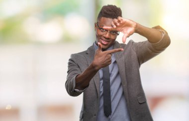 Elle yapma çerçeve ve parmakları ile mutlu yüz gülümseyen izole arka plan üzerinde genç Afro-Amerikalı iş adamı. Yaratıcılık ve Fotoğrafçılık kavramı.