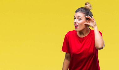 Genç güzel kadın bir işitme söylenti ya da dedikodu için dinleme kulak üzerinde el ile gülümseyen izole arka plan yüzünden. Sağırlık kavramı.