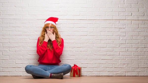 Young Redhead Woman Sitting Brick Wall Wearing Christmas Hat Shocked — Stock Photo, Image