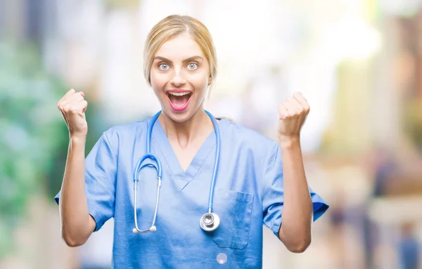 若い美しい金髪の医者の外科医は腕を上げると 驚きと驚きの成功を祝う孤立の背景に看護師の女性と目を開きます 勝者の概念 — ストック写真