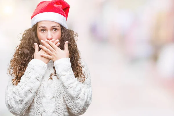 若いブルネットの少女は 孤立した背景のミスのための手で口を覆っているショックを受けた上クリスマス帽子をかぶっています 秘密の概念 — ストック写真