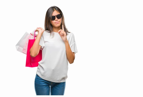 販売に関する質問は 非常に混乱して考え分離背景深刻な顔を考えての上レジ袋を保持している若いアジア女性 — ストック写真