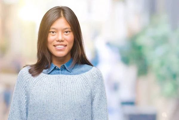 若いアジア女性の顔に幸せとクールな笑顔で孤立した背景に冬のセーターを着ています 幸運な人 — ストック写真