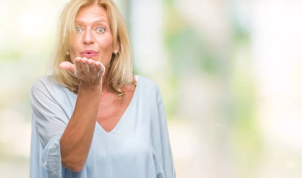 Medelålders Blond Affärskvinna Över Isolerade Bakgrund Tittar Kameran Blåser Kyss — Stockfoto