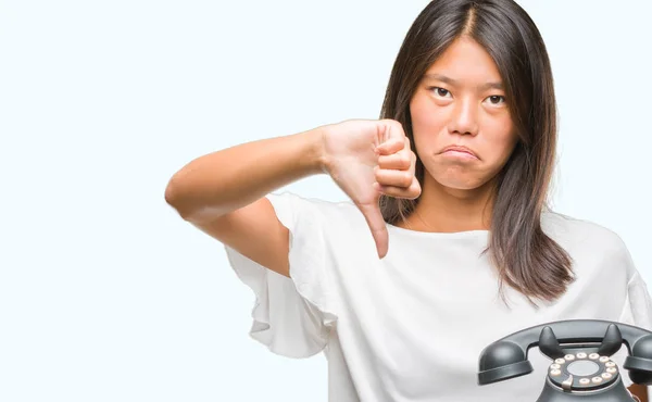 怒った顔 ダウン親指で嫌悪感を示すマイナス記号 拒絶反応の概念と分離の背景に Vintagera 電話を保持している若いアジア女性 — ストック写真