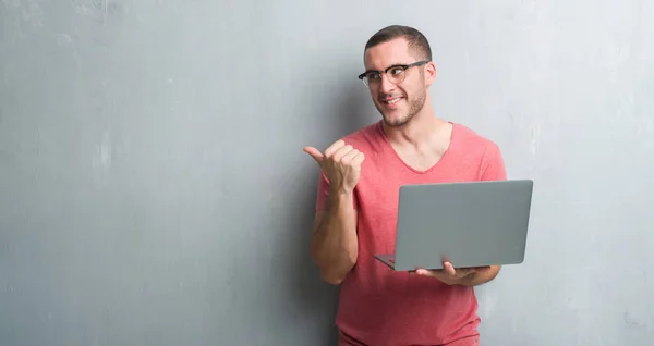 Joven Caucásico Hombre Sobre Gris Grunge Pared Usando Ordenador Portátil —  Fotos de Stock