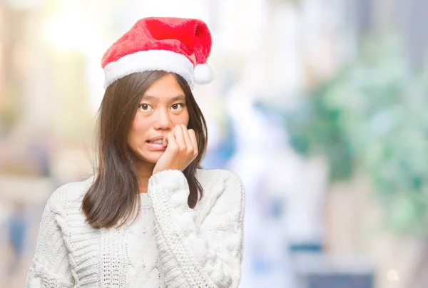 年轻的亚洲妇女戴着圣诞帽 在与世隔绝的背景下 手上叼着钉子 神情紧张和不安 焦虑问题 — 图库照片