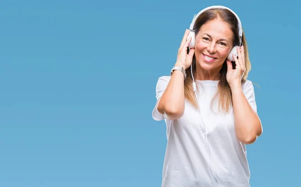 中世纪西班牙裔妇女听音乐戴着耳机 在与世隔绝的背景下 脸上带着愉快而凉爽的笑容 幸运的人 — 图库照片