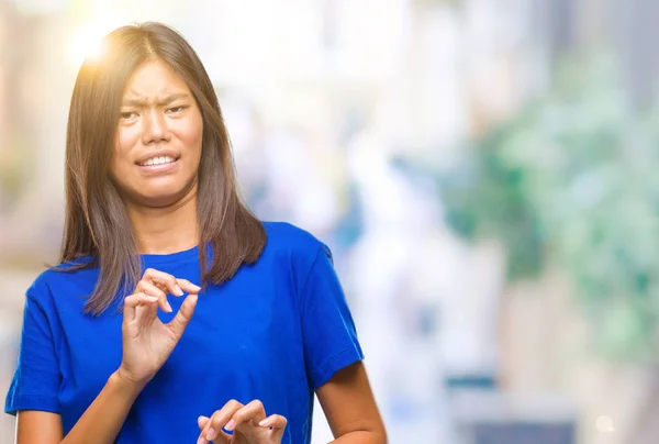 Young asian woman over isolated background disgusted expression, displeased and fearful doing disgust face because aversion reaction. With hands raised. Annoying concept.