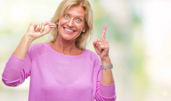 Blond Žena Středního Věku Jedl Růžové Macaron Sušenku Izolované Pozadí — Stock fotografie