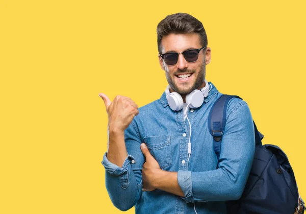 Junger Gutaussehender Touristenmann Mit Kopfhörern Und Rucksack Über Isoliertem Hintergrund — Stockfoto