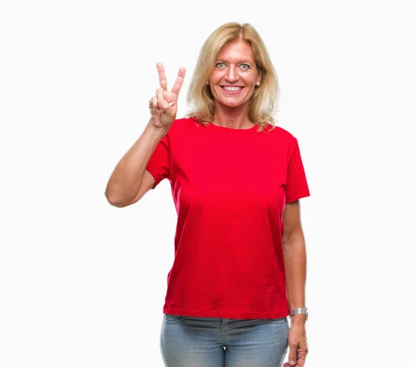 中年金发女人在孤立的背景显示 并指出手指第二 而微笑着自信和快乐 — 图库照片