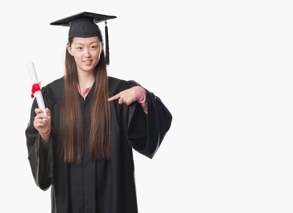 Mladá Číňanka Postgraduální Uniformě Drží Papír Stupeň Překvapením Tvář Ukazováčkem — Stock fotografie
