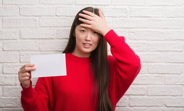 Jovem Chinesa Sobre Parede Tijolo Segurando Papel Branco Estressado Com — Fotografia de Stock