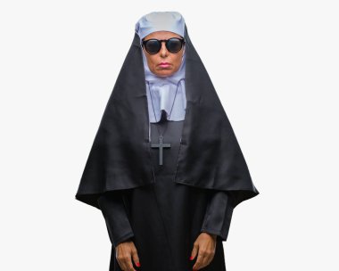 Orta yaş üst düzey Katolik Rahibe kadın yüzünde ciddi bir ifade ile izole arka plan üzerinde güneş gözlüğü takıyor. Basit ve doğal kameraya bakıyor.