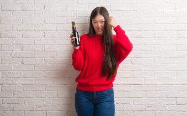 Tuğla duvar içki bira rahatsız Genç Çinli kadın ve boşa çıkarmak ile öfke, çılgın ve yükseltilmiş eliyle diye bağıran öfke kavramı bağırarak.