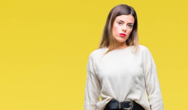 Genç güzel kadın yüzünde ciddi bir ifade ile izole arka plan üzerinde rahat beyaz kazak. Basit ve doğal kameraya bakıyor.